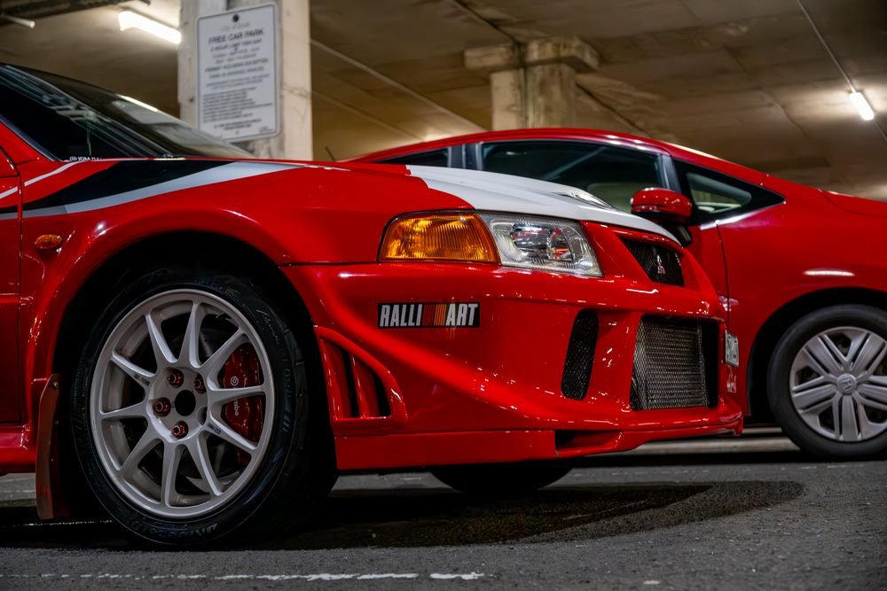 Red Mitsubishi Lancer Evolution VI Ralliart on white wheels in a Sydney carpark at night