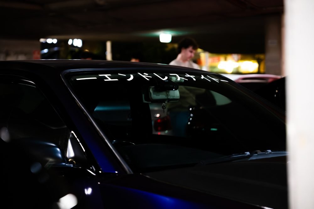 Ferraris, imports and modified cars under carpark lighting at a late-night Sydney car meet (frame 9 of 40)