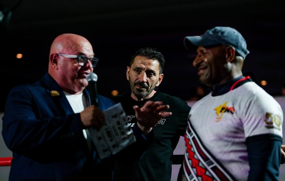 Officials reading the judges' scorecards in the ring after a bout