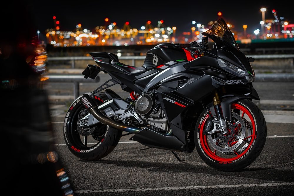 Sportbike photographed from dusk into full dark against Sydney's working harbour (frame 5 of 8)