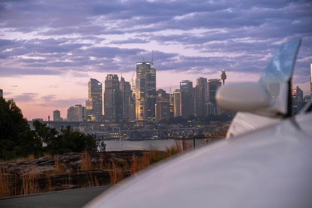 Nissan Skyline GTS photographed against the Sydney city skyline and Harbour Bridge at sunset (frame 1 of 12)
