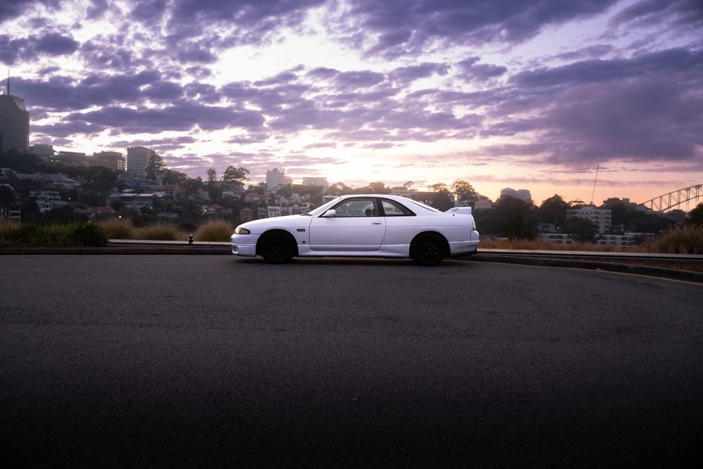 Nissan Skyline GTS photographed against the Sydney city skyline and Harbour Bridge at sunset (frame 3 of 12)