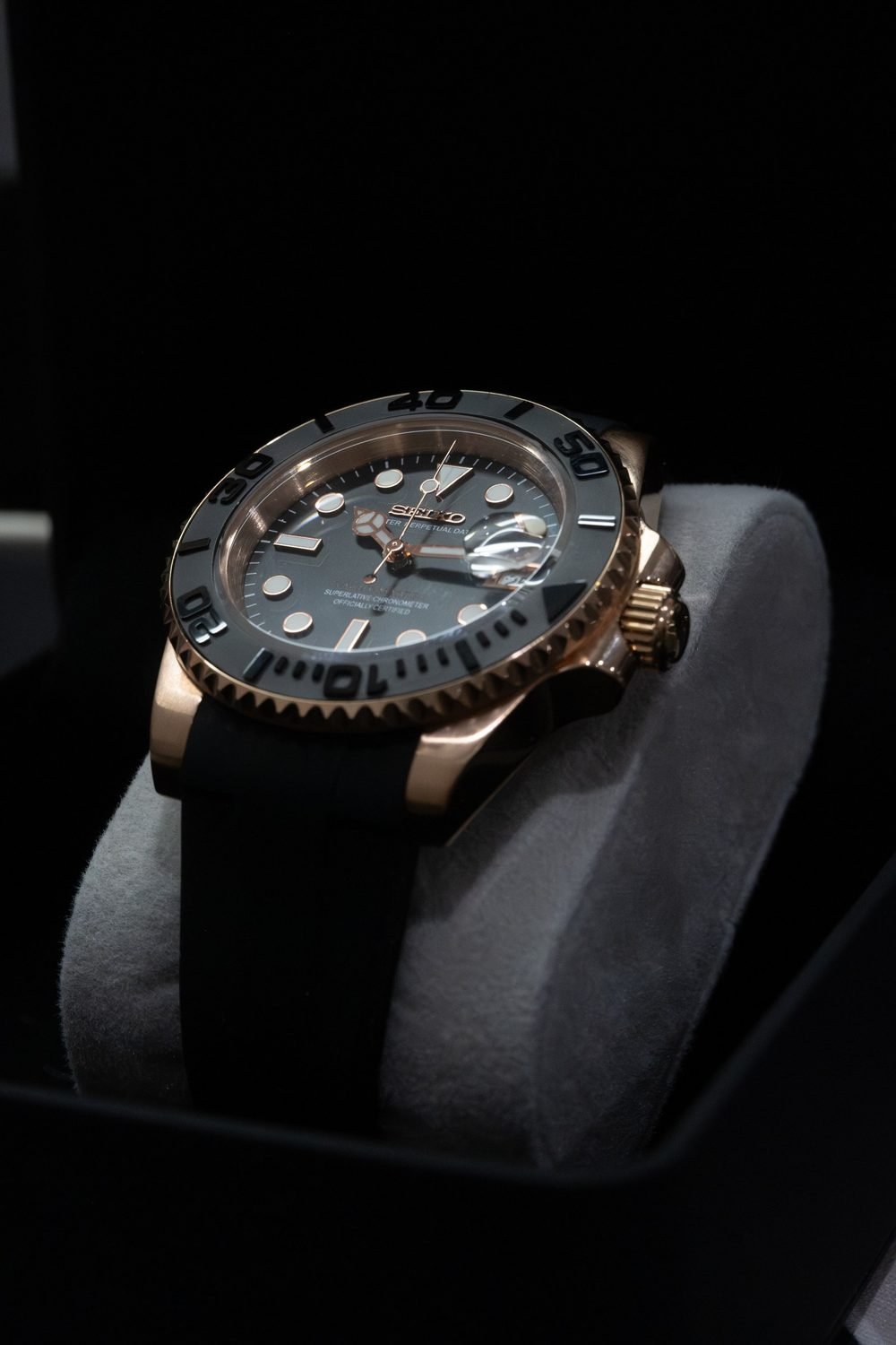 Rose gold dive watch with a black ceramic bezel on a rubber strap