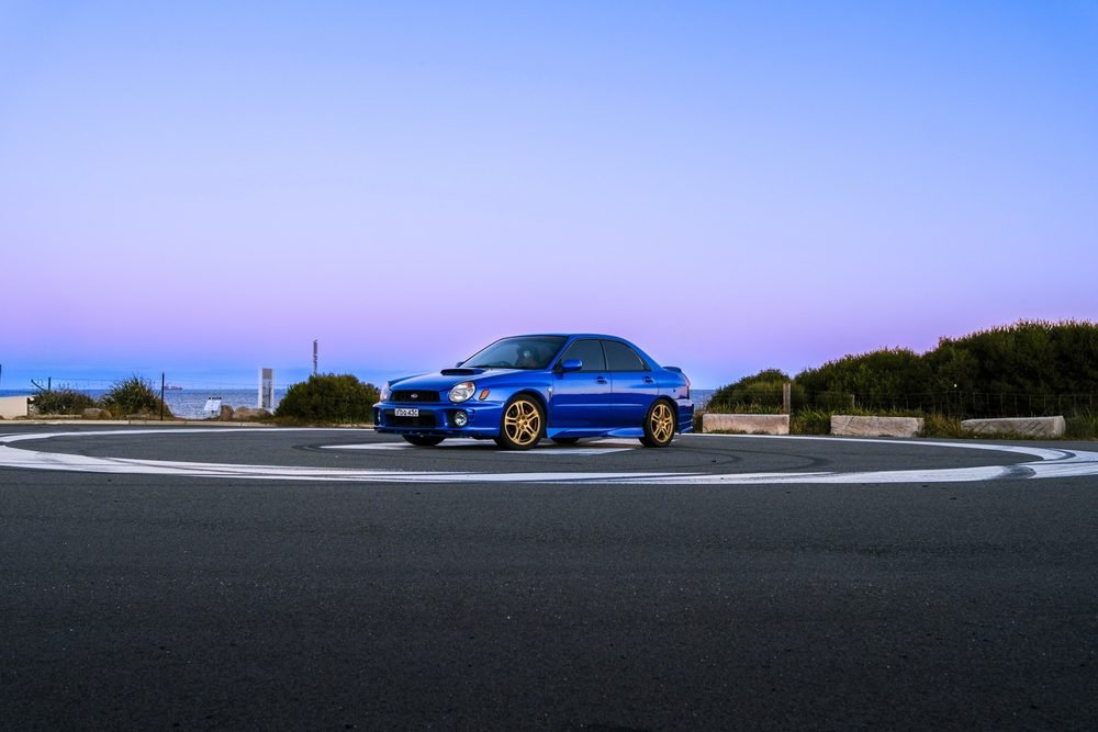 Subaru Impreza WRX STI on gold wheels at a New South Wales coastal lookout during blue hour (frame 2 of 12)