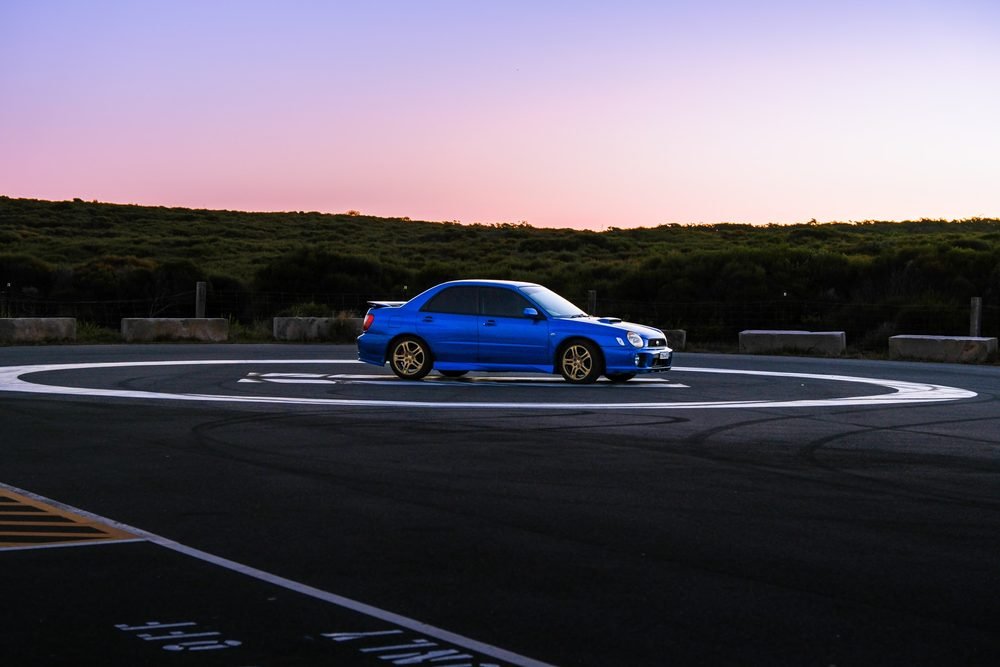 Subaru Impreza WRX STI on gold wheels at a New South Wales coastal lookout during blue hour (frame 4 of 12)
